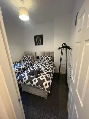 two twin beds in a room with a door at Anfield cosy stay in Liverpool