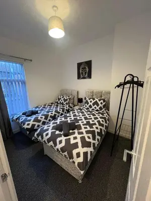 a bedroom with two beds and a window at Anfield cosy stay in Liverpool
