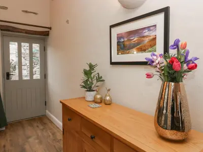 a vase filled with flowers sitting on top of a dresser at Lady Barn in Grange Over Sands
