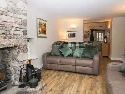 a living room with a couch and a fireplace at Lady Barn in Grange Over Sands