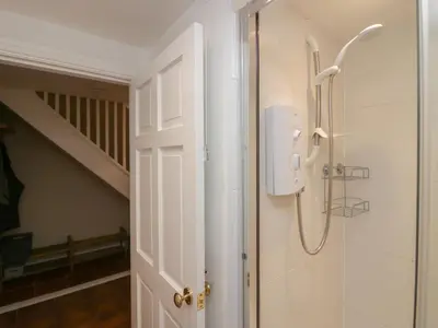 a shower in a bathroom with a white door at Lady Barn in Grange Over Sands