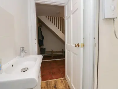 a bathroom with a sink and a staircase at Lady Barn in Grange Over Sands