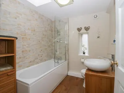 a bathroom with a tub and a sink and a toilet at Lady Barn in Grange Over Sands