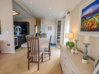 a kitchen and dining room with a table and chairs at Otters Reach in Carnforth