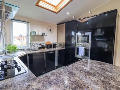 a kitchen with black appliances and a counter top at Otters Reach in Carnforth