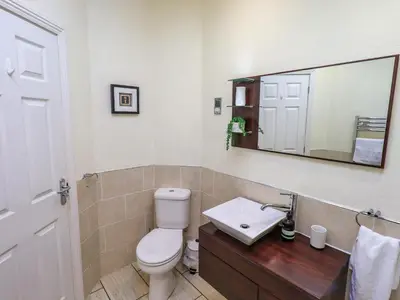 a bathroom with a toilet and a sink and a mirror at Otters Reach in Carnforth