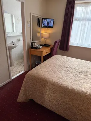 a hotel room with a bed and a bathroom at Adelaide House Hotel - Opposite Winter Gardens, Town Centre in Blackpool