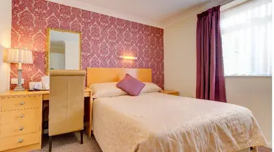a bedroom with a bed and a desk and a mirror at Adelaide House Hotel - Opposite Winter Gardens, Town Centre in Blackpool
