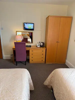 a hotel room with a desk and a bedroom at Adelaide House Hotel - Opposite Winter Gardens, Town Centre in Blackpool