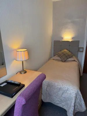 a bedroom with a bed and a lamp on a table at Adelaide House Hotel - Opposite Winter Gardens, Town Centre in Blackpool