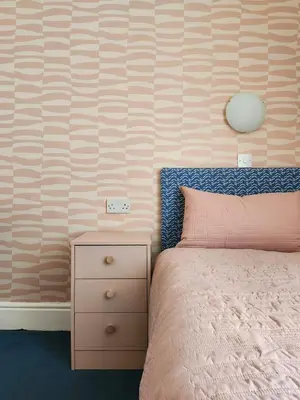 a bedroom with a pink bed and a night stand at The Everglades in Blackpool