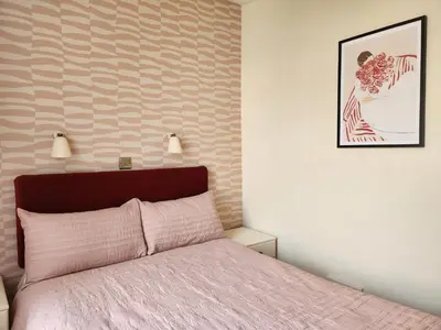 a bedroom with a bed with a pink bedspread at The Everglades in Blackpool