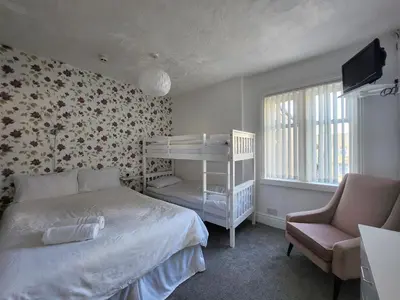 a bedroom with a bunk bed and a chair at The Everglades in Blackpool