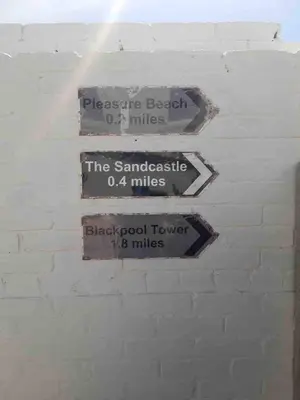 a group of signs on a white brick wall at Ocean Suites HOT TUB - sleeps 11 in Blackpool