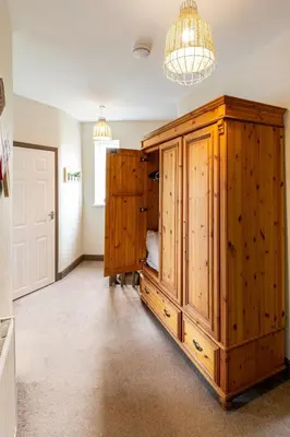 a room with wooden cabinets and a chandelier at Ocean Suites HOT TUB - sleeps 11 in Blackpool