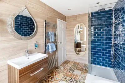 a bathroom with a sink and a shower and a mirror at Ocean Suites HOT TUB - sleeps 11 in Blackpool
