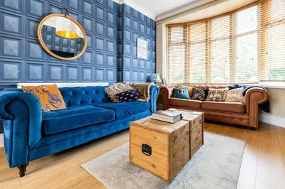 a living room with a blue couch and a table at Ocean Suites HOT TUB - sleeps 11 in Blackpool