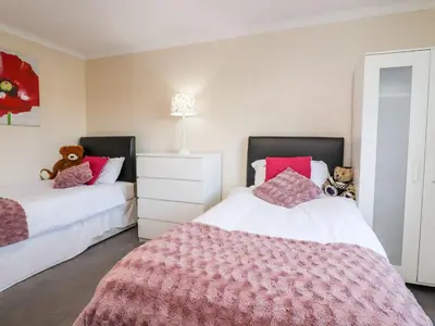a bedroom with two beds with red and white sheets at Arnside House in Carnforth