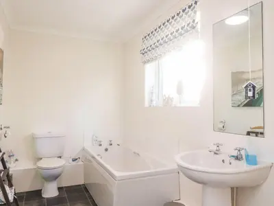 a white bathroom with a toilet and a sink at Arnside House in Carnforth