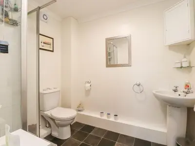 a white bathroom with a toilet and a sink at Arnside House in Carnforth