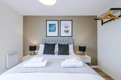 a bedroom with a large white bed with two lamps at Stunning Top-Floor 2BR Free Parking & Stylish Stay in Liverpool
