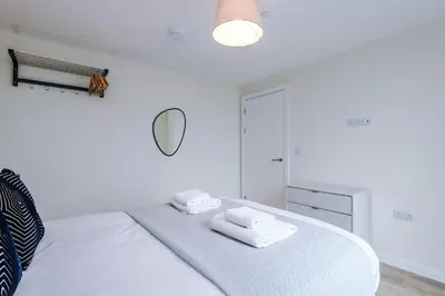a white bedroom with a bed with towels on it at Stunning Top-Floor 2BR Free Parking & Stylish Stay in Liverpool