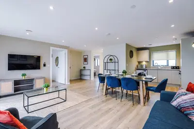 a living room with a couch and a table at Stunning Top-Floor 2BR Free Parking & Stylish Stay in Liverpool
