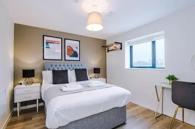 a bedroom with a large bed and a window at Stunning Top-Floor 2BR Free Parking & Stylish Stay in Liverpool