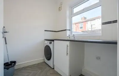 a laundry room with a washing machine and a window at Property is sold in Liverpool