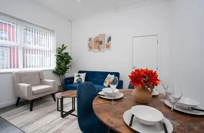 a living room with a table and a blue couch at Property is sold in Liverpool