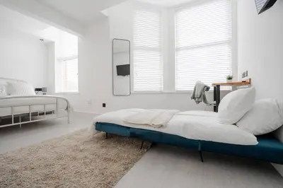 a white bedroom with a bed and a mirror at Private Stay by Anfield Shared Kitchen Parking in Liverpool