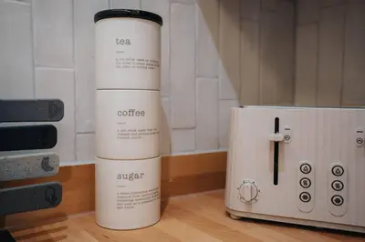 two white bottles sitting on a counter next to a toaster at Private Stay by Anfield Shared Kitchen Parking in Liverpool