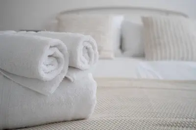 a pile of towels sitting on top of a bed at Private Stay by Anfield Shared Kitchen Parking in Liverpool