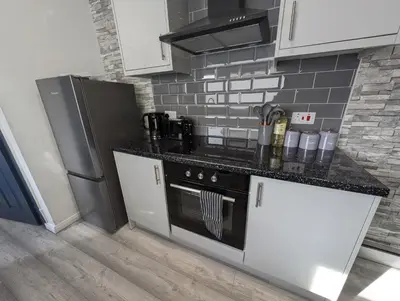a kitchen with a stove and a refrigerator at 3Bed 2Bath house - Free Parking - Close to Everton & Liverpool FC- Managed by Chique Properties Ltd in Liverpool