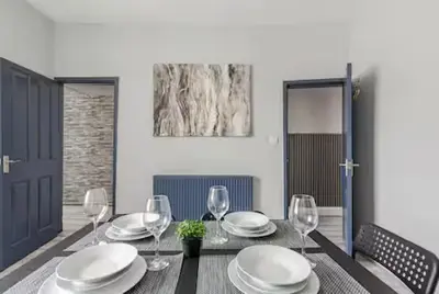 a dining table with plates and wine glasses on it at 3Bed 2Bath house - Free Parking - Close to Everton & Liverpool FC- Managed by Chique Properties Ltd in Liverpool