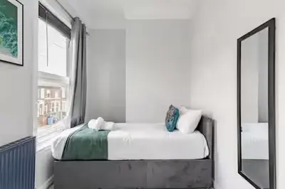 a white bedroom with a bed and a mirror at 3Bed 2Bath house - Free Parking - Close to Everton & Liverpool FC- Managed by Chique Properties Ltd in Liverpool