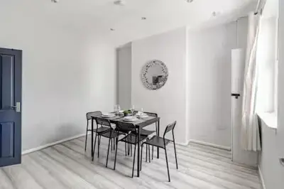 a dining room with a black table and chairs at 3Bed 2Bath house - Free Parking - Close to Everton & Liverpool FC- Managed by Chique Properties Ltd in Liverpool