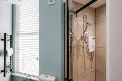 a shower in a bathroom with a glass door at Work Desk Shared Kitchen Budget Parking in Liverpool
