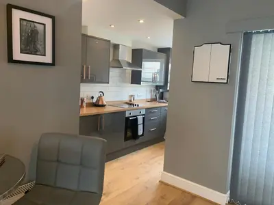 a kitchen with a table and a chair in a room at Seaside Suites sleep 8 in Blackpool
