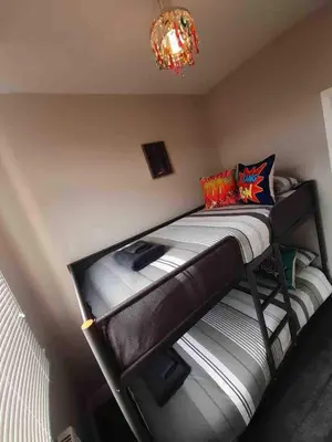 a bunk bed in a room with a chandelier at Seaside Suites sleep 8 in Blackpool