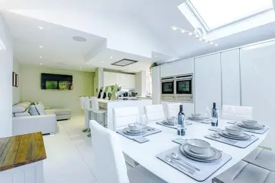 a white dining room with a white table and chairs at 4 Bed House Relocators Trades and long stays in Samlesbury