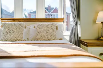 a bed with white pillows and a window at 4 Bed House Relocators Trades and long stays in Samlesbury