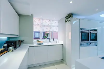 a kitchen with white cabinets and a sink at 4 Bed House Relocators Trades and long stays in Samlesbury