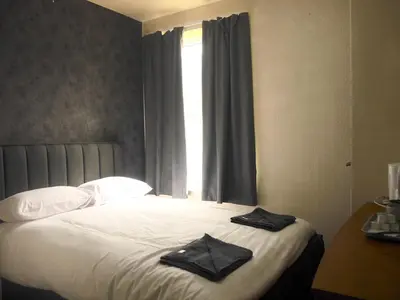 a bedroom with a bed with two black towels on it at The Stone House Hotel in Blackpool