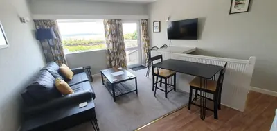 a living room with a couch and a table at Ivy's in Grange Over Sands