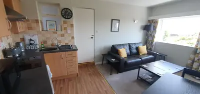 a small living room with a couch and a kitchen at Ivy's in Grange Over Sands
