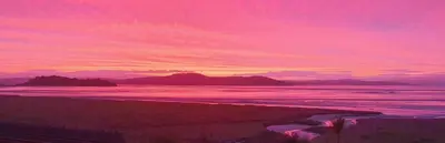 a sunset over a beach with mountains in the background at Ivy's in Grange Over Sands