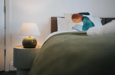a bedroom with a bed with a lamp on a table at Property is sold in Liverpool