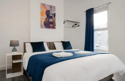 a bedroom with a large bed with a blue blanket at Property is sold in Liverpool
