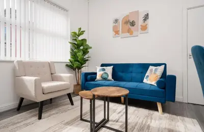 a living room with a blue couch and a chair at Property is sold in Liverpool